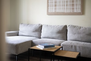 A grey sofa with a small wooden table and a book in front of it. - Stay U-nique Apartments Sagrada Familia (Barcelona)