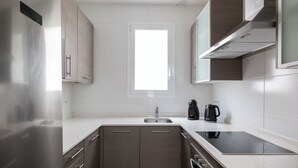 A modern kitchen with a built-in oven, a sink, and a window above the countertop. - Stay U-nique Apartments Sagrada Familia (Barcelona)