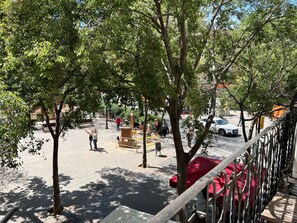 Un espace extérieur aménagé avec des tables et des chaises, entouré d’arbres.