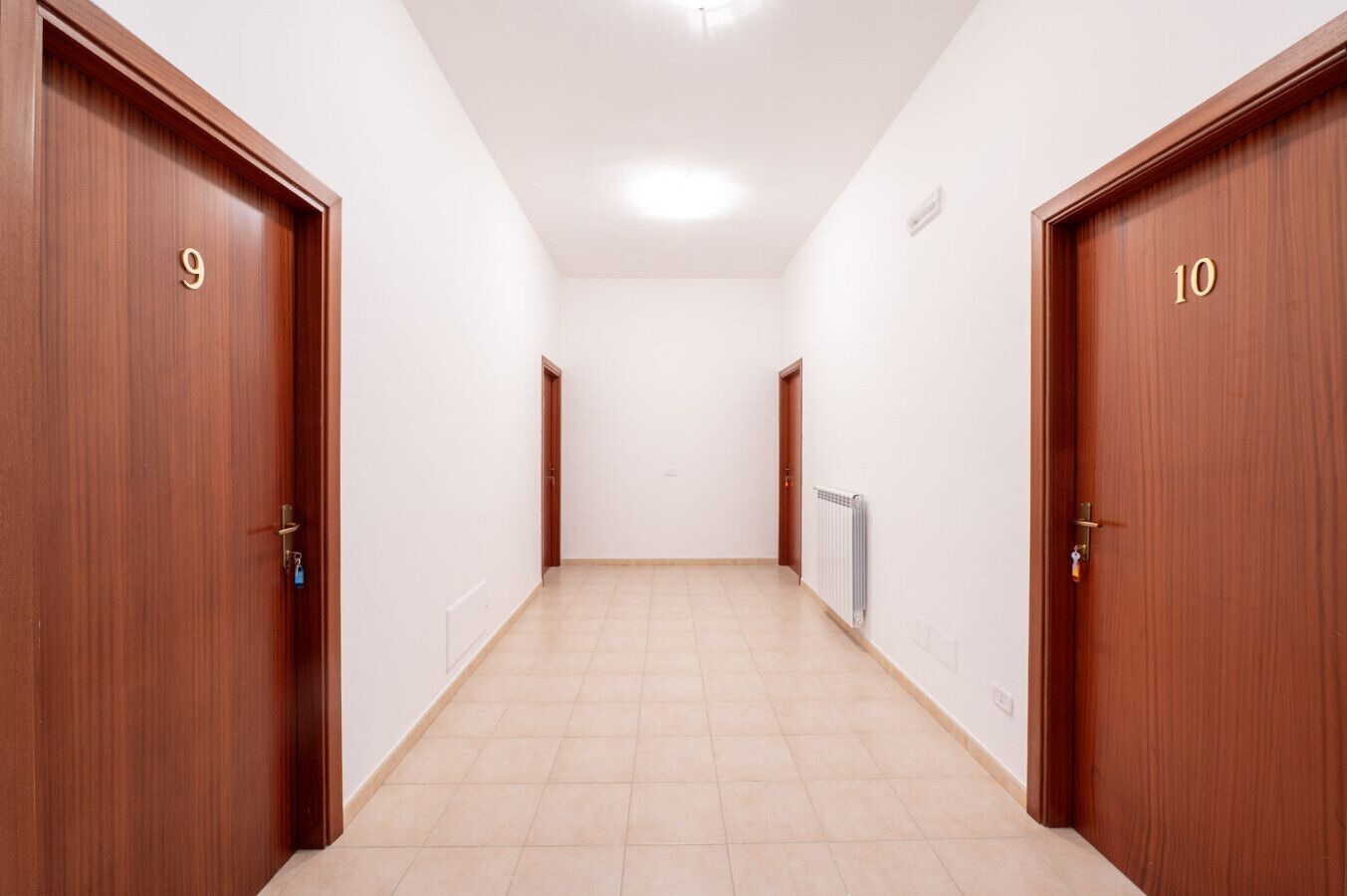 A hallway with two wooden doors labeled 9 and 10, leading to rooms.