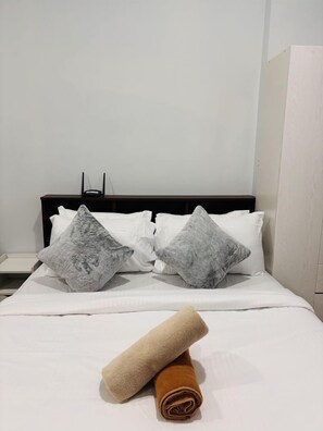 Tabla de planchar con plancha y ropa de cama