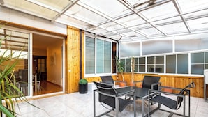 Une salle de réunion moderne, dotée d’une table en verre, de chaises et de plantes en pot.