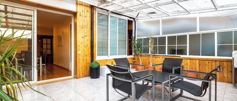 Una sala de reunions moderna amb taula de vidre, cadires i plantes en testos.