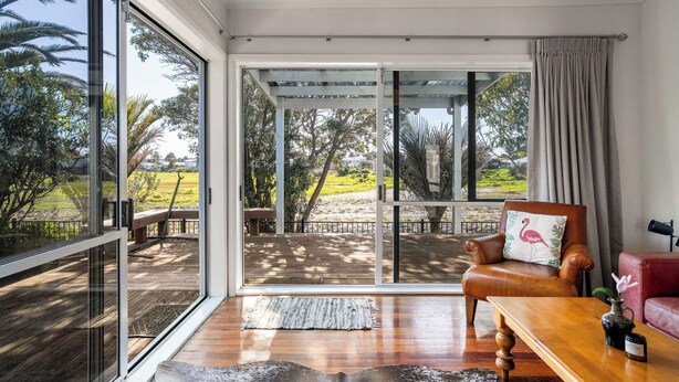A spacious room with a large sliding glass door leading to an outdoor deck.