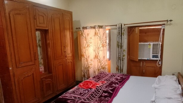 Un dormitorio con cama, armario y aire acondicionado.