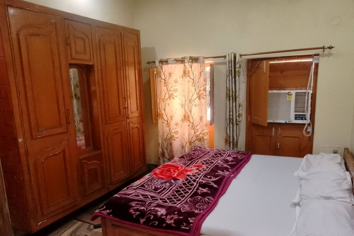 Un dormitorio con cama, armario y aire acondicionado.