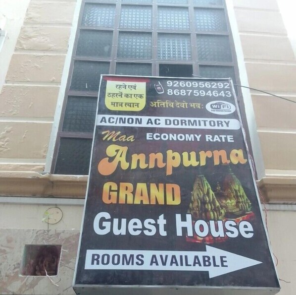 A sign for a guest house with a contact number and a Wi-Fi symbol. - Maa Annapurna grand guests house  (Varanasi)