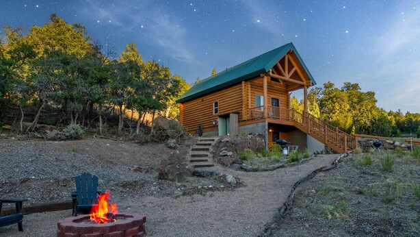 A log cabin with a balcony, a fire pit, and a stone staircase leading up to the entrance. - National Parks - Cowboy Hot tub and UFO Sightings (Alton)