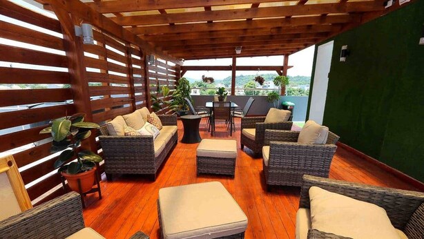 A covered outdoor seating area with wicker furniture and a wooden ceiling. - Lovely 2 Bd-2Bath Apt w. A|C Garage & Rooftop (San Cristobal)