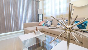 A modern living room with a glass coffee table, a beige sofa with patterned cushions, and a metallic floor lamp. - Lovely 2 Bd-2Bath Apt w. A|C Garage & Rooftop (San Cristobal)
