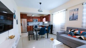 A modern apartment with a kitchen, dining area, and living room.