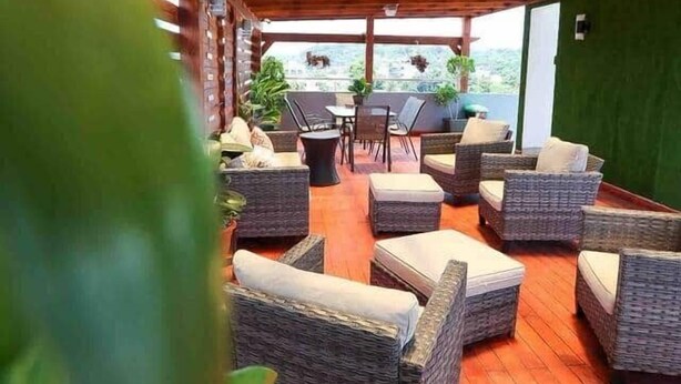 An outdoor seating area with wicker furniture and a wooden ceiling structure. - Beautiful 2Bd/2bath apt W. AC, Garage  & roof top (San Cristobal)