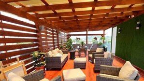 An outdoor seating area with wicker furniture and a wooden pergola. - Beautiful 2Bd/2bath apt W. AC, Garage  & roof top (San Cristobal)