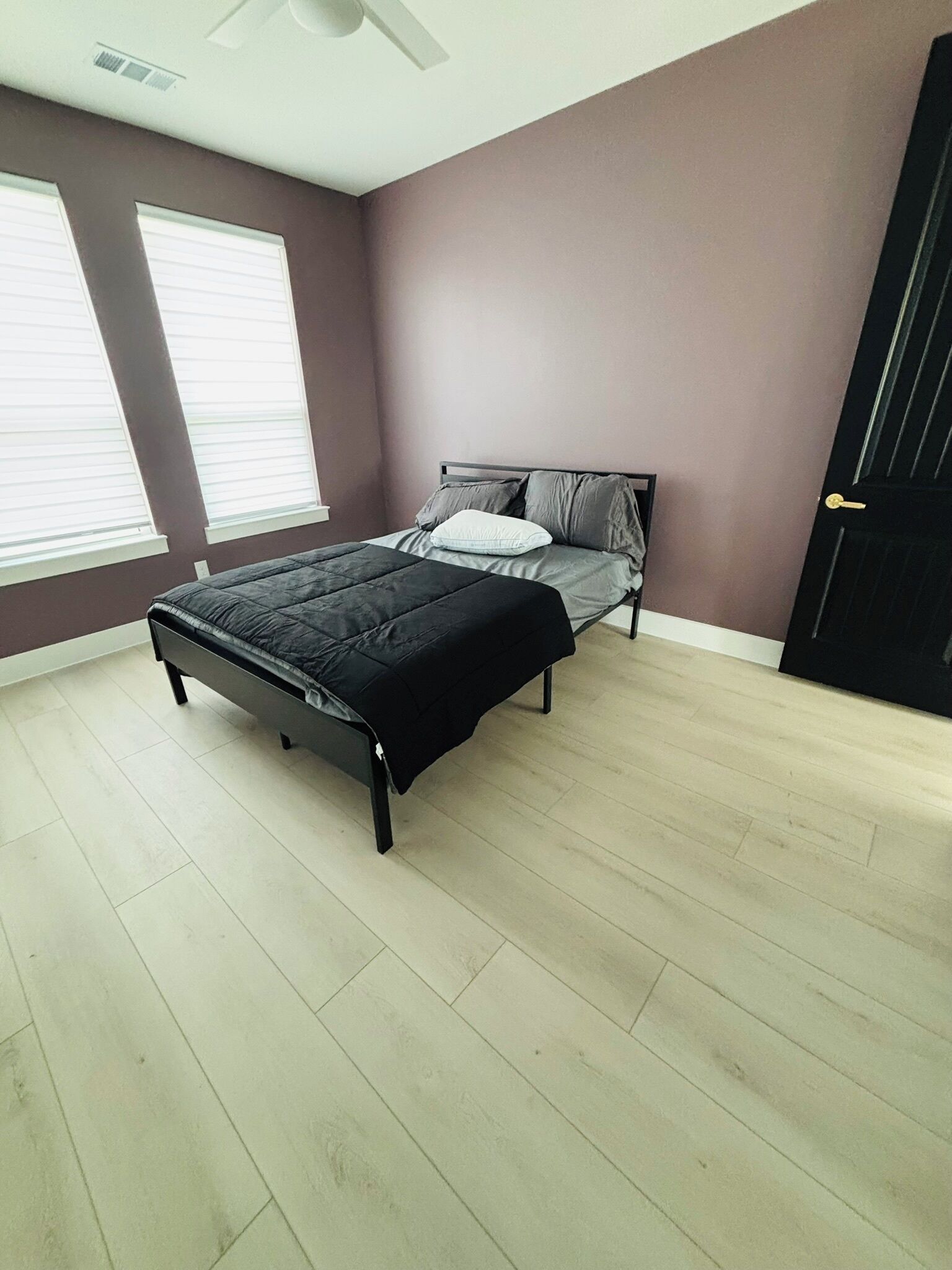 Un dormitorio con cama, ventana y puerta.