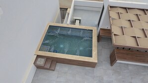 A room with a glass-enclosed hot tub, a wooden bench, and a tiled floor.