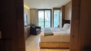 Un dormitorio amplio con una cama grande, un sofá y vistas a la ciudad.