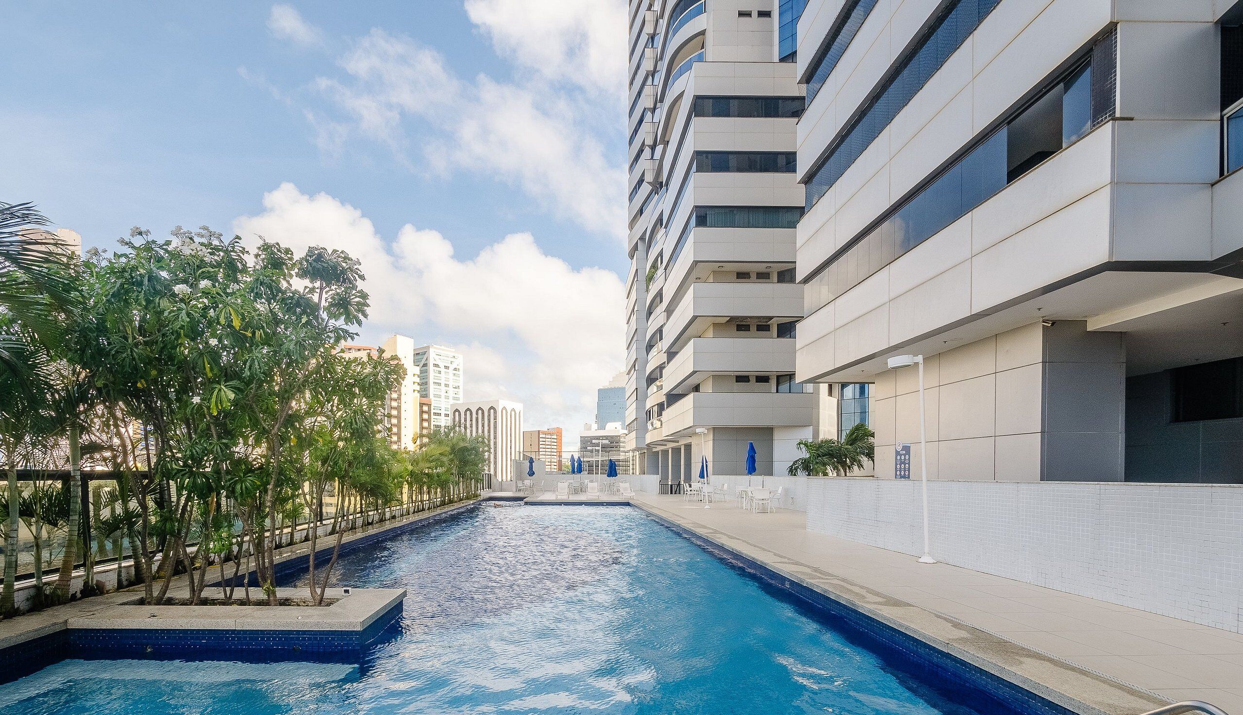 A swimming pool with a modern building in the background.
