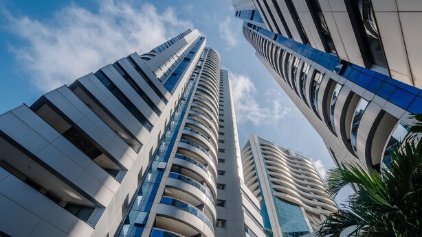 Een modern hoog gebouw met een gebogen gevel en meerdere balkons.