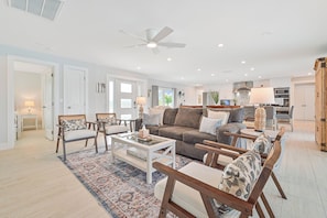 A spacious living room with a sofa, chairs, a coffee table, and a rug. - Riverside Retreat, "Views to Live By"-Pool & Riverside (Fort Myers)