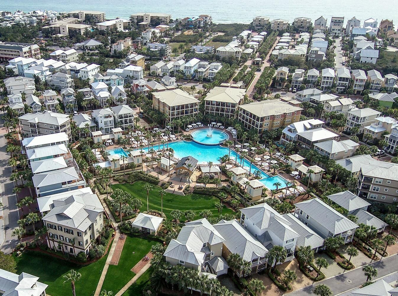 Luchtfoto van een resort met meerdere gebouwen, een centraal gelegen zwembad en omliggend groen.