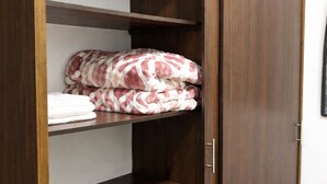 A wooden wardrobe with multiple shelves and a sliding door. - Two rooms AREAS by QuBeLab (Bello)
