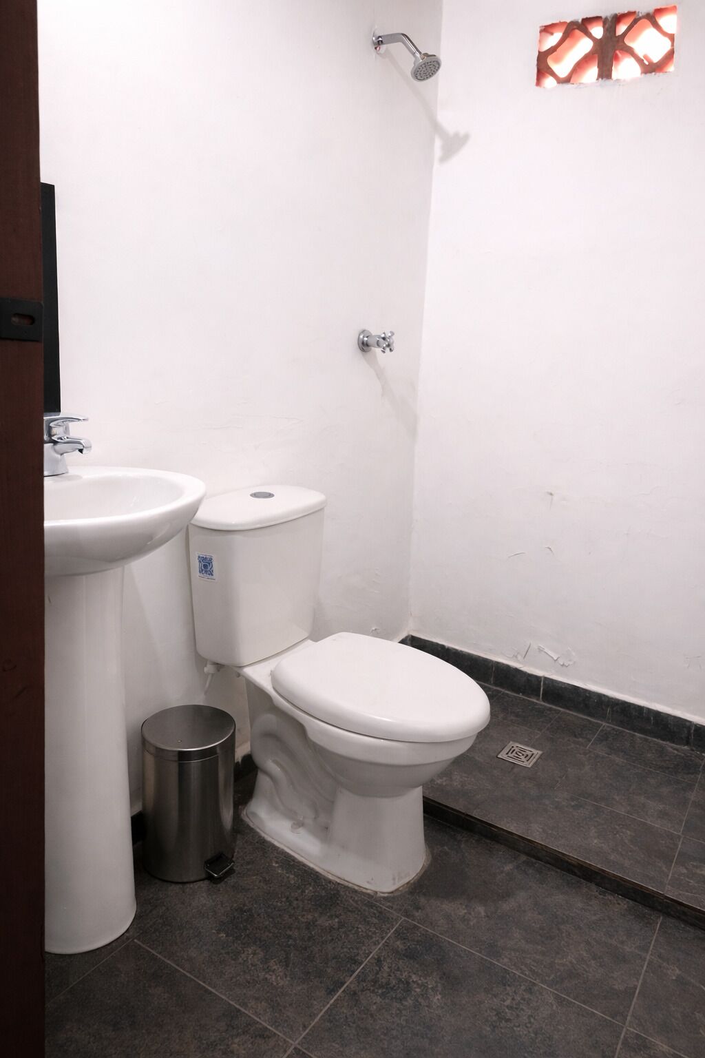 A bathroom with a toilet, sink, and shower.