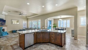A spacious kitchen with a large island, wooden cabinets, and a modern design. - Havasu Duke - Pool, Spa, Basketball, Central (Lake Havasu City)