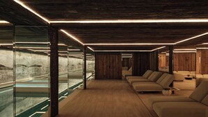 Un interior moderno con techo de madera, paredes de vidrio y un área de descanso con sofás.