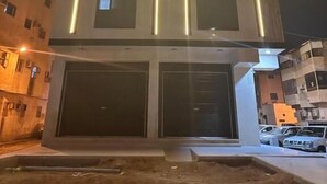 A modern building with a central vertical light strip and multiple windows. - Saba Munawara Al Masi (Madinah)