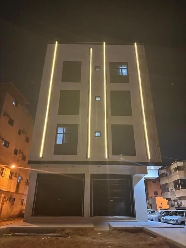 A modern building with a central vertical light strip and multiple windows.