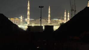 A night view of a cityscape with illuminated minarets and buildings. - Saba Munawara Al Masi (Madinah)