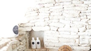 A stone wall with two bottles of AERIN on a shelf. - Breakfast Incl | Caribbean Escape | Ocean Views (Buck Island)