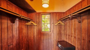 Une pièce en bois avec un banc, une fenêtre et un luminaire suspendu.