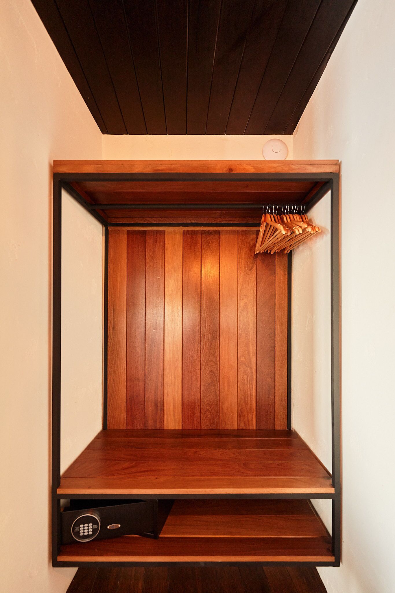 A wooden cabinet with a built-in TV shelf and a remote control drawer.