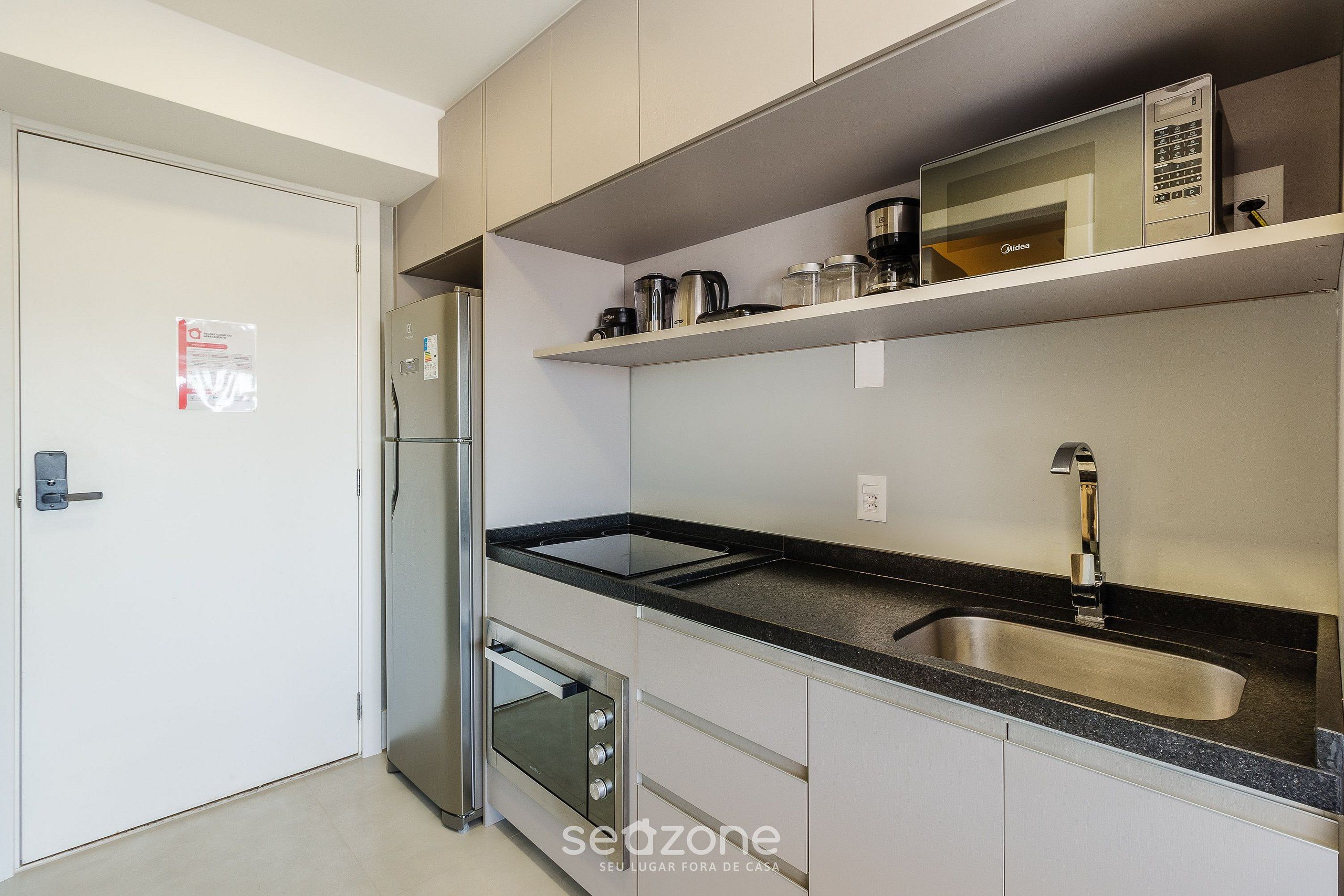 Una cocina moderna con refrigerador de acero inoxidable, horno empotrado y pileta doble.