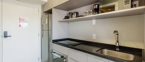 Una cocina moderna con refrigerador de acero inoxidable, horno empotrado y pileta doble.