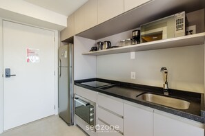 Eine moderne Küche mit einem Edelstahl-Kühlschrank, einem eingebauten Backofen und einer Spüle mit zwei Becken.