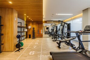 A gym with treadmills, weight machines, and a wooden wall with a 'No Smoking' sign. - Studio Completo ao Lado da PUCRS c/ Garag CON1506 (Porto Alegre)