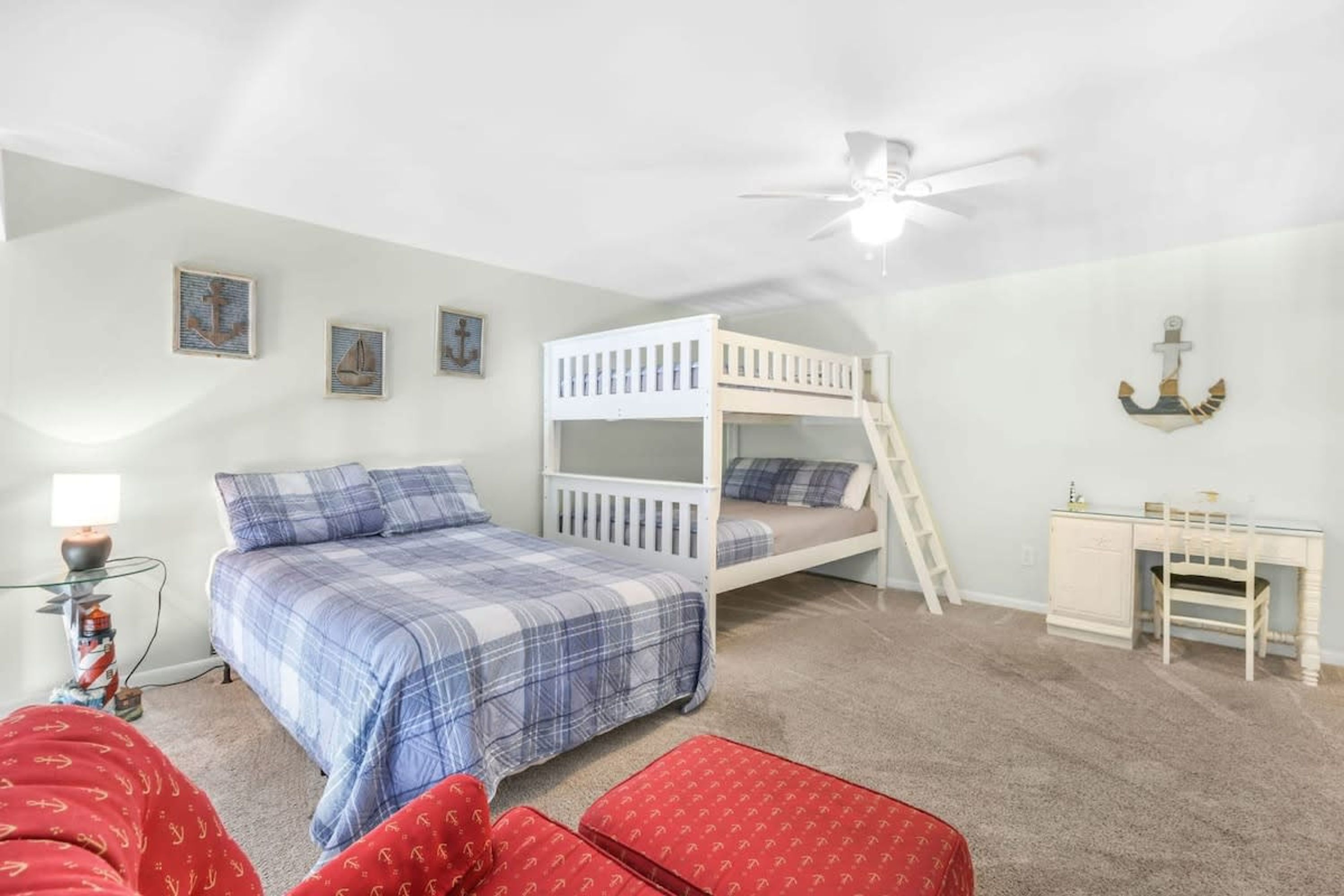 A bedroom with a bunk bed, a desk, and a chair.