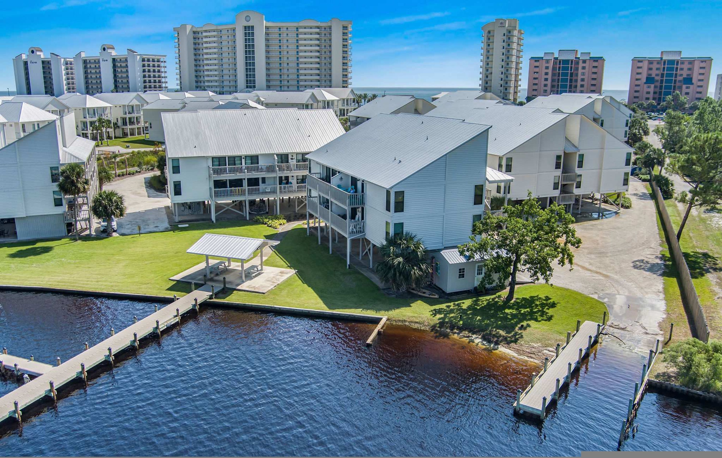 A coastal hotel with multiple buildings, a dock, and a marina.