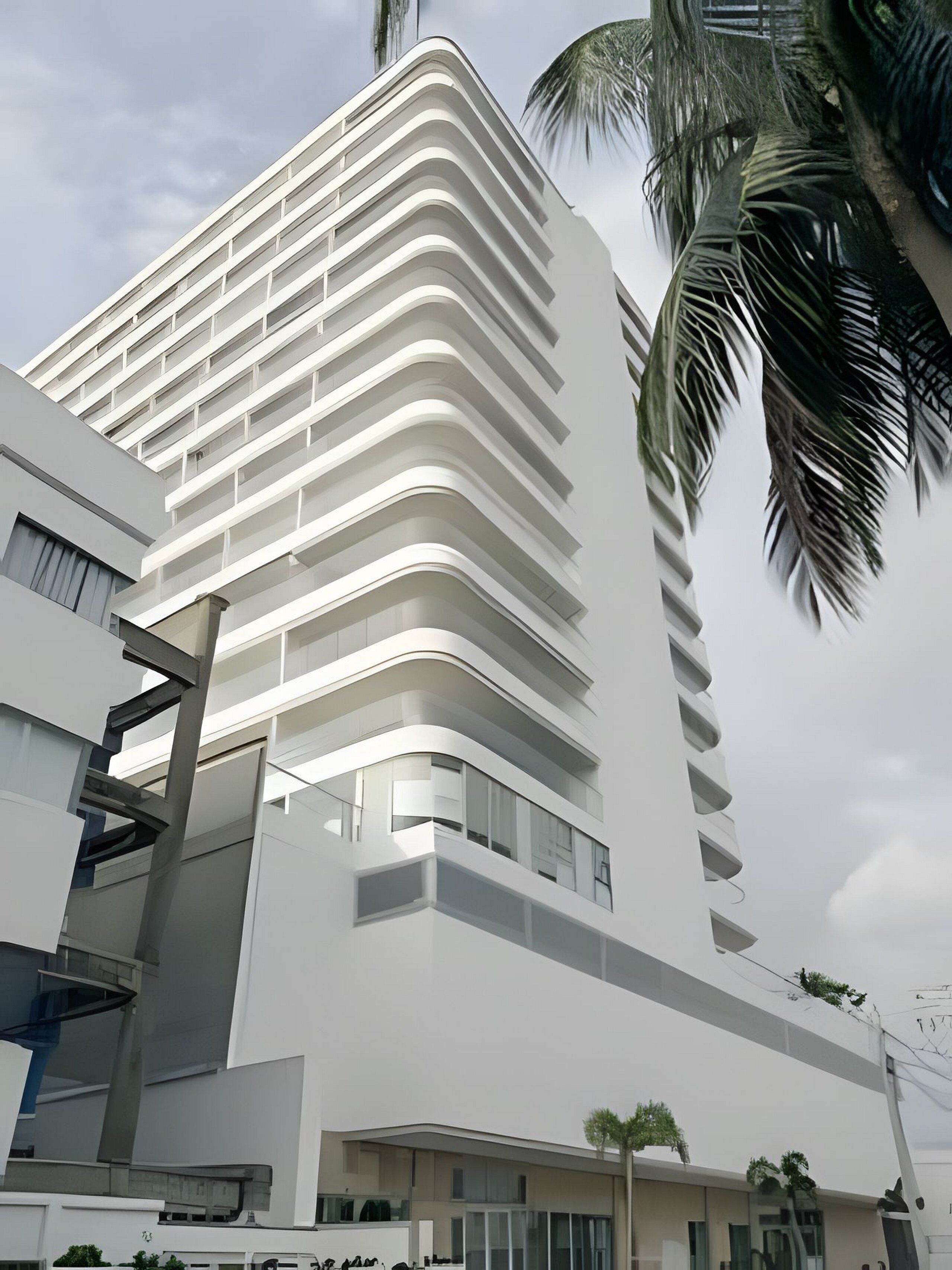 A modern high-rise building with a curved facade and multiple balconies.