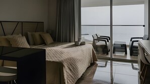 Una habitación de hotel moderna con una cama grande, un escritorio y un balcón con vistas.