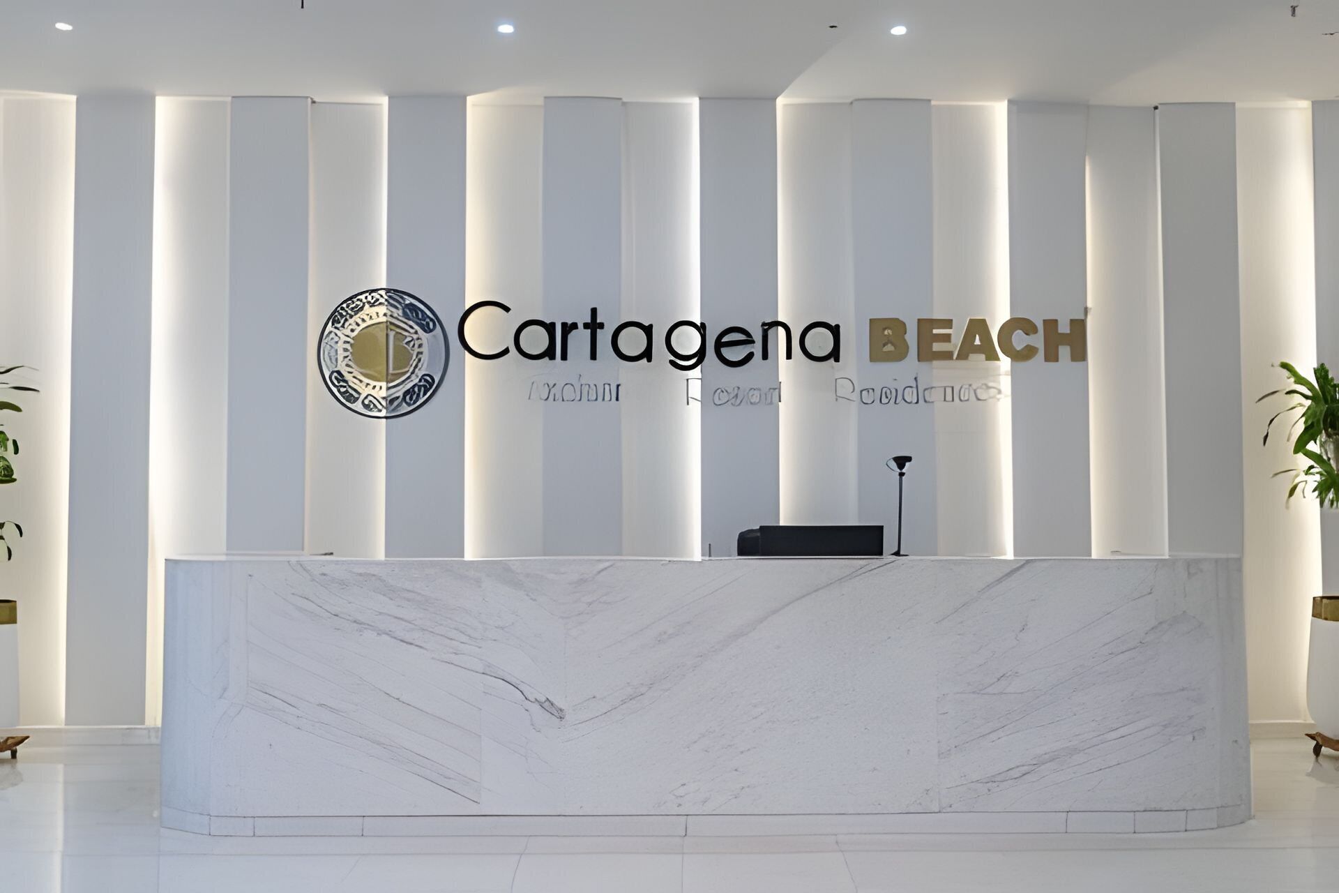 A reception desk with a logo and the name 'Cartagena Beach' on the wall.