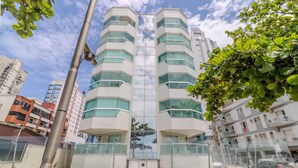 A multi-story building with a modern architectural design, featuring large windows and balconies. - 3BR Seafront apt w/ BBQ in Itapema Con0101 (Itapema)