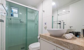 A modern bathroom with a glass-enclosed shower, a white sink with a large bowl, and a toilet. - Cozy 3BR apt W/balcony sea View Cet1702 (Balneário Camboriú)