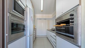 Una cocina con dos hornos, una estufa y un refrigerador.