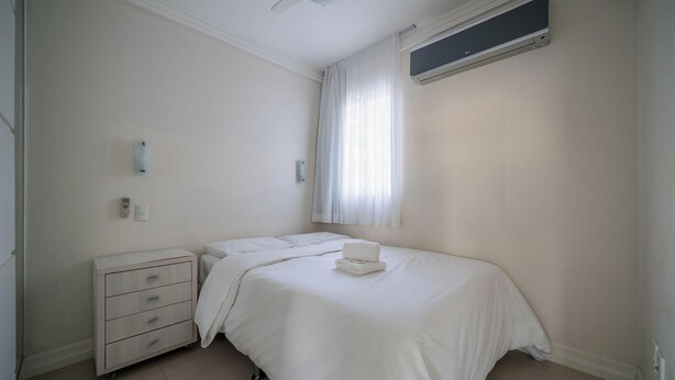 Un dormitorio con cama, mesita de noche, cómoda y ventilador de techo, además de aire acondicionado.