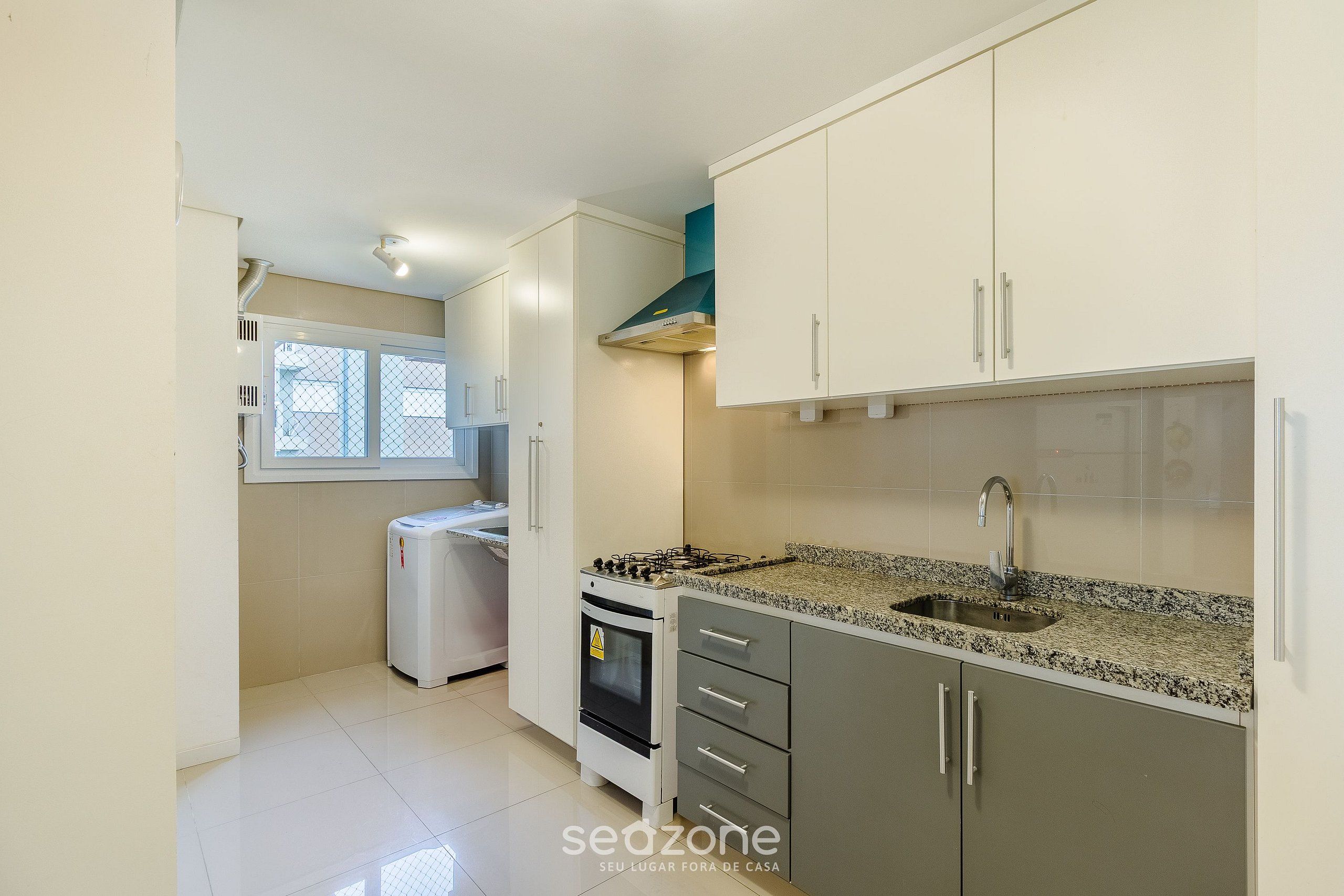 A kitchen with white cabinets, a granite countertop, a stove, and a sink.