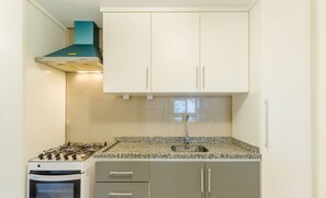 A kitchen with white cabinets, a gas stove, a built-in oven, and a stainless steel sink. - Apt in Canela Facing Duck Lake Cbl307 (Canela)