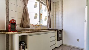 Una cocina compacta con horno integrado, cafetera y lavavajillas.